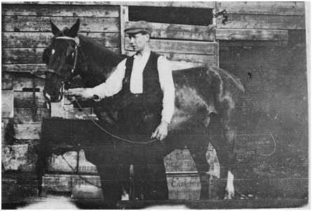 Photo from C.1915 – Charles Woodrow with one of the firms early forms of transport.