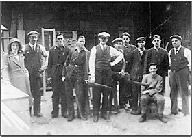 Photo C. 1930 – John Jackson (centre) with sons John Jnr. & William (3rd & 4th from left), daughter Margaret (left) and other members of staff, probably at Mill Street.