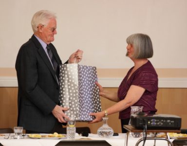 Photo of George Robertson receiving his presentation from Carolyn Thompson
