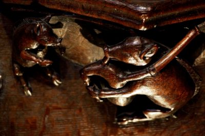 Photo of carvings of a pig playing the bagpipes on the misericords