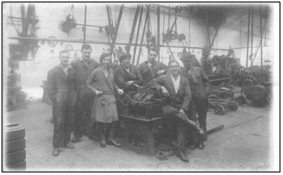 Photo of Tod’s Workshop c.1938 with Rennie Tod and Stuart Bowman (2nd and 4th from the left). In the background to the right can be seen the flywheel of the oil engine used to drive the overhead pulley system.